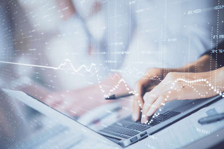 Double exposure of woman hands typing on computer and forex chart hologram drawing. Stock market...