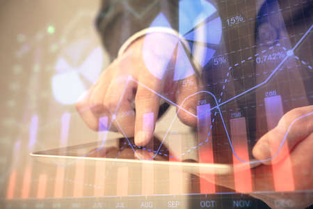 Multi exposure of mans hands holding and using a phone and financial chart drawing. Market analysis...