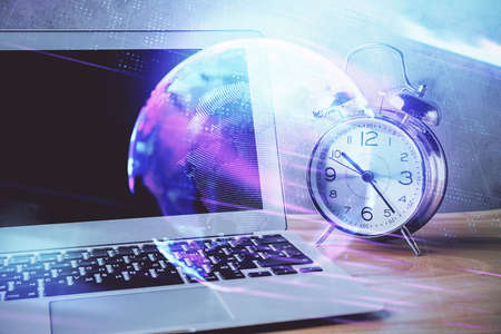 Computer on desktop in office with technology theme hologram. Double exposure. Tech concept.