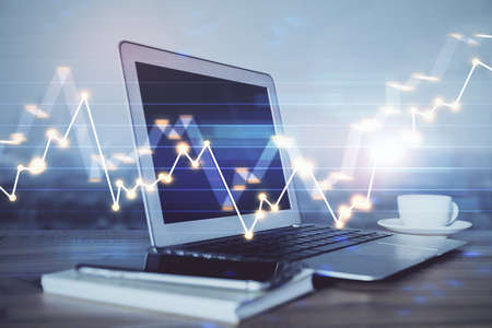Stock market graph on background with desk and personal computer. Double exposure. Concept of...
