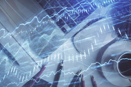 Double exposure of financial chart drawing over table background with computer. Concept of research...
