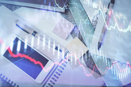 Multi exposure of forex graph hologram over desktop with phone. Top view. Mobile trade platform...