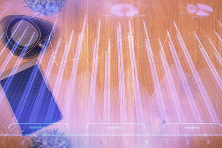 Multi exposure of financial chart hologram over desktop with phone. Top view. Mobile trade platform...