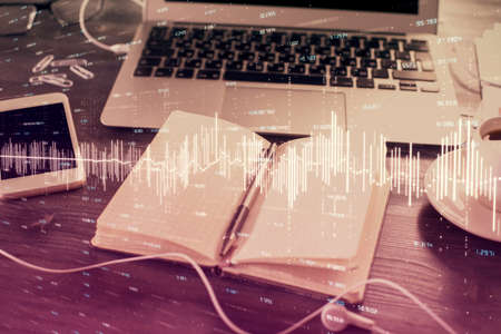 Multi exposure of financial graph drawings and desk with open notebook background. Concept of forex