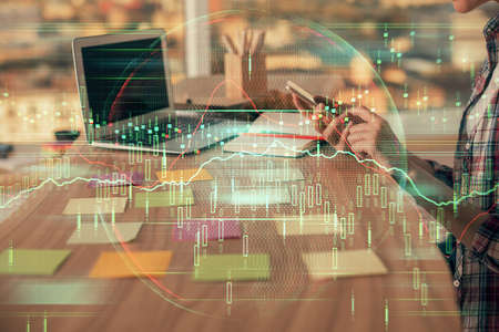 Double exposure of woman hands working on computer and forex graph hologram drawing. Financial...