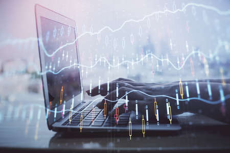 Double exposure of woman hands typing on computer and forex chart hologram drawing. Stock market...