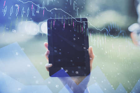 Double exposure of forex chart sketch hologram and woman holding and using a mobile device....