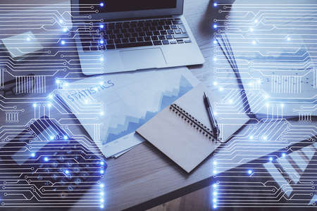 Computer on desktop in office with technology theme hologram. Double exposure. Tech concept.