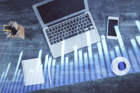 Double exposure of forex chart drawing over table background with computer. Concept of financial...