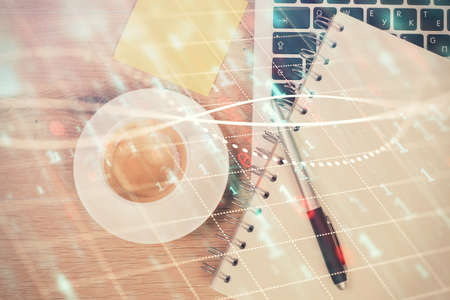Double exposure of financial chart drawing over table background with computer. Concept of research and analysis. Top view.の写真素材