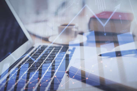 Double exposure of financial chart drawing and desktop with coffee and items on table background....