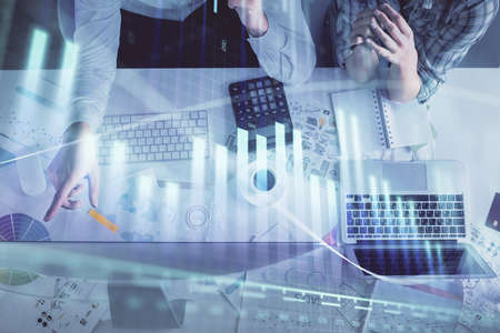 Double exposure of man and woman working together and financial graph hologram drawing. market...