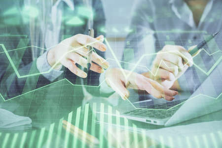 Multi exposure of man and woman working together and financial chart hologram. Business concept....