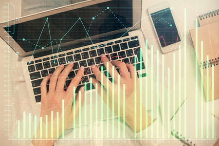Double exposure of woman hands working on computer and forex chart hologram drawing. Top View....