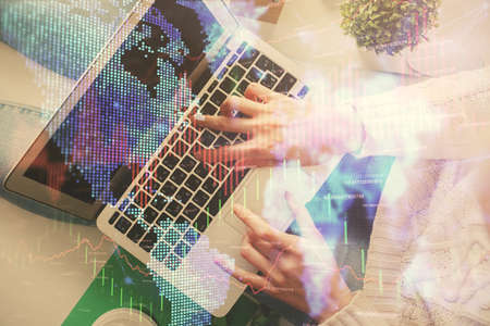 Double exposure of woman hands working on computer and forex chart hologram drawing. Top View....