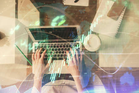 Double exposure of woman hands working on computer and forex chart hologram drawing. Top View....