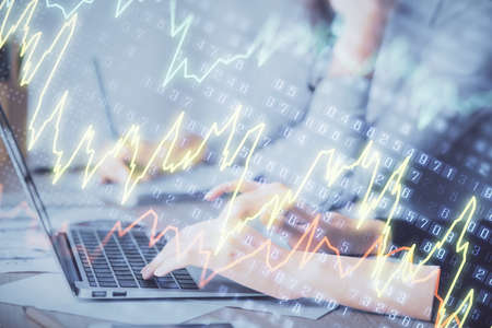 Multi exposure of woman hands typing on computer and financial chart hologram drawing. Stock market...