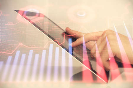 Multi exposure of mans hands holding and using a digital phone and forex graph drawing. Financial market concept.の写真素材