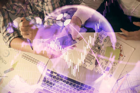 Double exposure of forex graph drawing and man and woman working together holding and using a mobile device. Trade concept.の写真素材