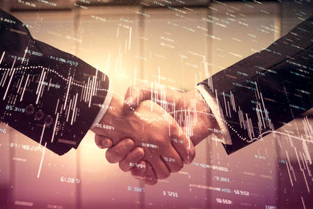 Double exposure of forex graph hologram and handshake of two men. Stock market concept.の写真素材