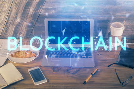 Double exposure of blockchain theme hologram and table with computer background. Concept of bitcoin...