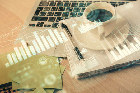 Double exposure of forex chart drawing and desktop with coffee and items on table background. Concept of financial market tradingの写真素材