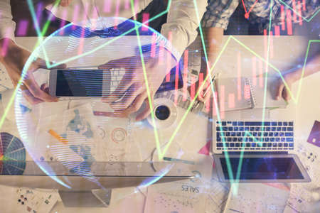 Double exposure of man and woman working together and financial chart hologram drawing. market...