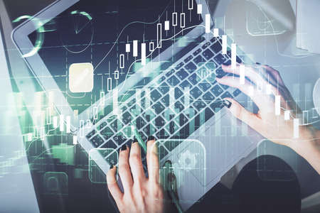 Double exposure of woman hands working on computer and forex chart hologram drawing. Top View....