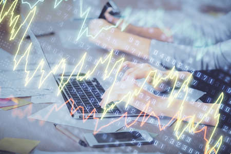 Multi exposure of woman hands typing on computer and financial chart hologram drawing. Stock market...