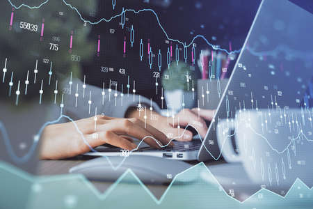 Double exposure of woman hands typing on computer and forex chart hologram drawing. Stock market...