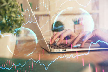 Double exposure of woman hands typing on computer and forex chart hologram drawing. Stock market...