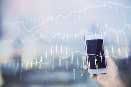 Double exposure of forex chart sketch hologram and woman holding and using a mobile device. Stock market concept.の写真素材