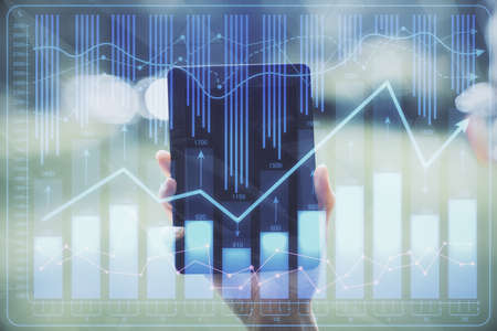 Double exposure of forex chart sketch hologram and woman holding and using a mobile device....