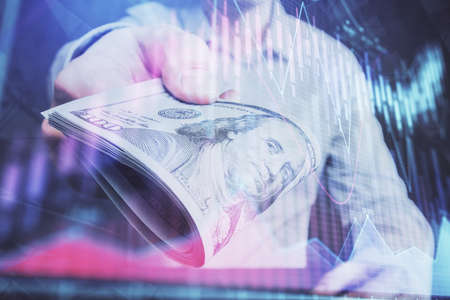 Multi exposure of financial graph drawing hologram and USA dollars bills and man hands. Analysis...