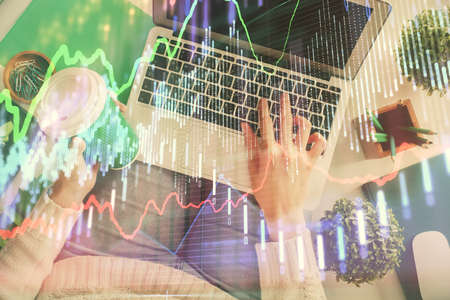Double exposure of woman hands working on computer and forex chart hologram drawing. Top View....