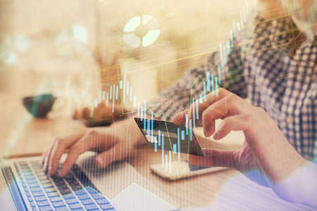 Double exposure of man hands holding a credit card and Forex graph drawing. Stock trading and...