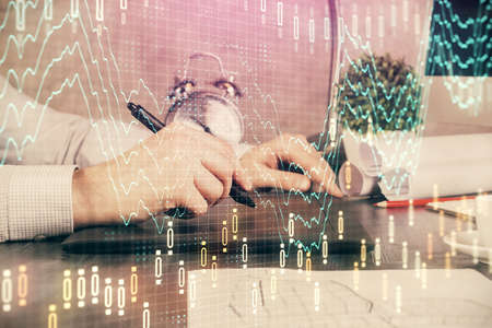 Double exposure of mans hands holding and using a phone and financial graph drawing. Analysis...