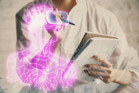 AR hologram over womans hands taking notes background. Concept of augmented reality. Multi exposureの写真素材