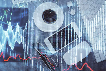 Multi exposure of forex graph hologram over desktop with phone. Top view. Mobile trade platform...
