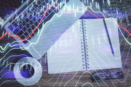 Financial market graph and top view computer on the desktop background. Double exposure. Investment...
