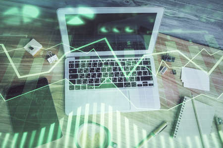 Double exposure of financial chart drawing over table background with computer. Concept of research...