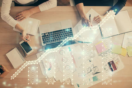 Double exposure of woman hands working on computer and forex graph hologram drawing. Top View....
