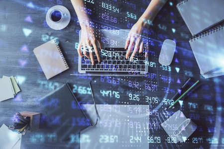 Multi exposure of woman hands working on computer and forex chart hologram drawing. Top View....