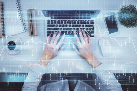 Double exposure of woman hands working on computer and forex chart hologram drawing. Top View....