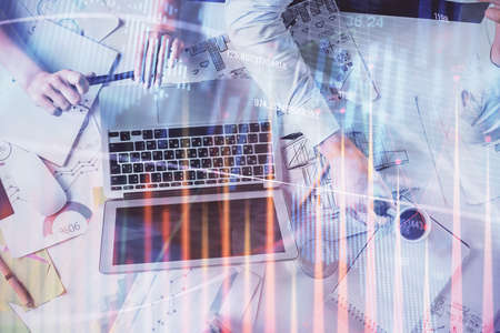 Double exposure of man and woman working together and financial graph hologram. Business concept....
