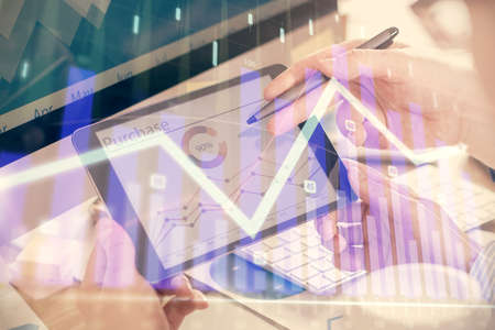Double exposure of mans hands holding and using a phone and financial chart drawing. Market analysis...
