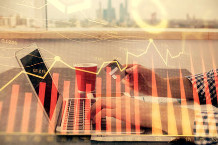 Double exposure of man hands holding a credit card and Forex graph drawing. Stock trading and...