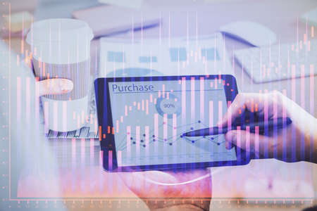 Double exposure of mans hands holding and using a phone and financial chart drawing. Market analysis...