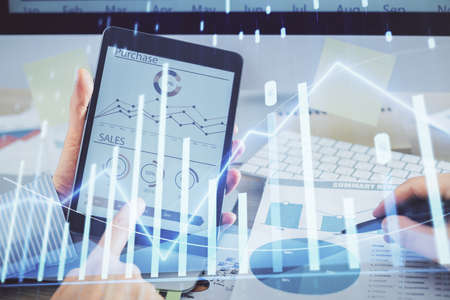 Multi exposure of mans hands holding and using a phone and financial chart drawing. Market analysis...