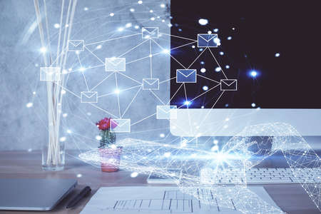 Desktop computer background in office and flying envelops hologram drawing. Double exposure....